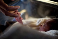 A man touches his newborn baby